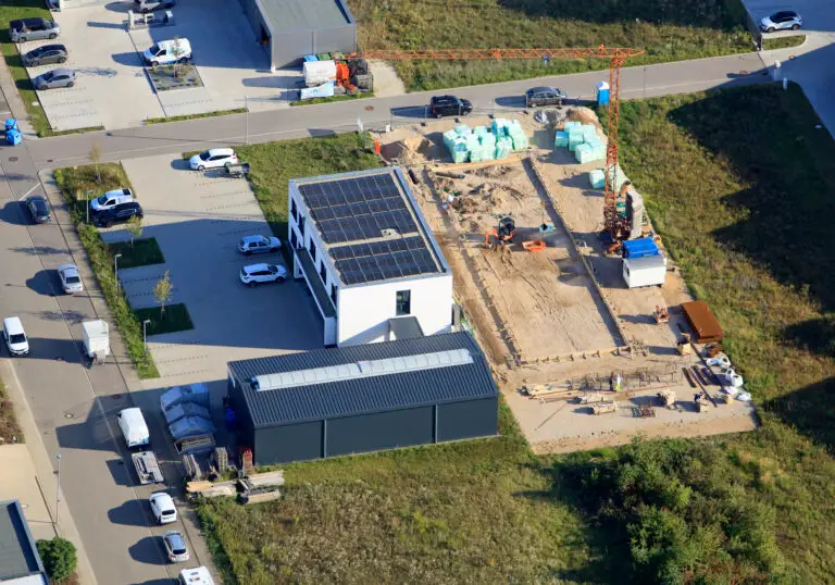 a building under construction with a crane and cars